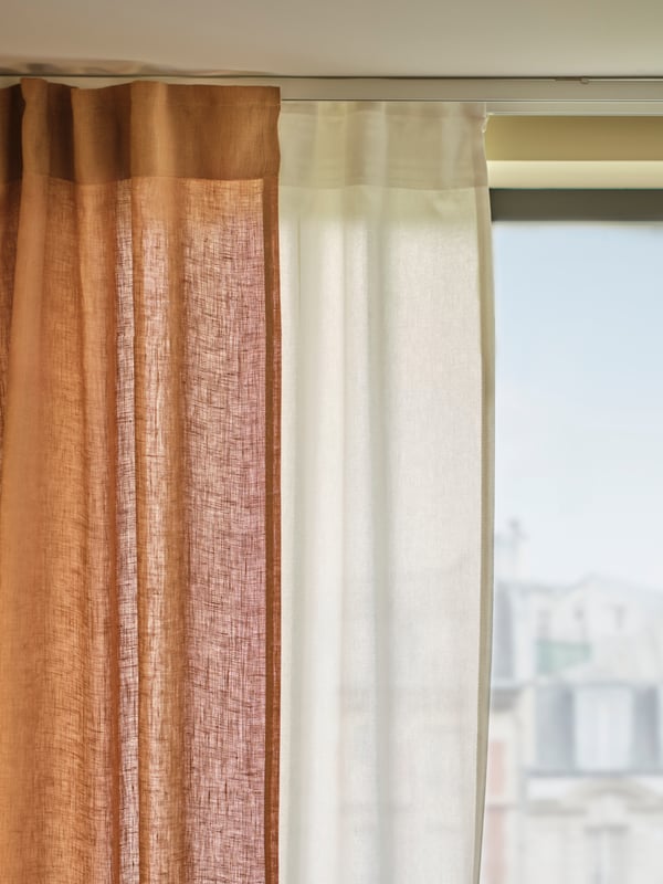 Acercamiento de la ventana con dos cortinas de tela, una de velo y sobre ella una cortina DYTÅG