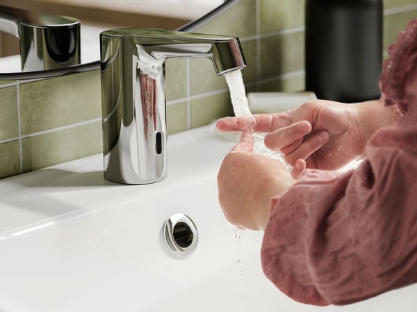Close-up of a childs hands while rinsing in a bathroom sink.