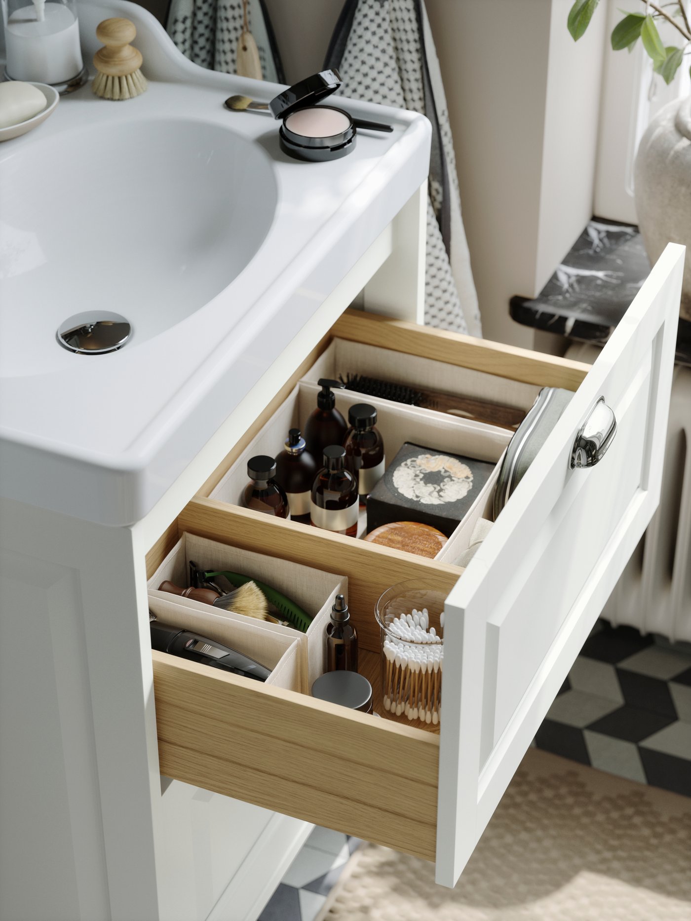A deep bathroom drawer in light grey, neatly organised with BOLLÖSUND boxes inside filled with bottles and cotton pads.