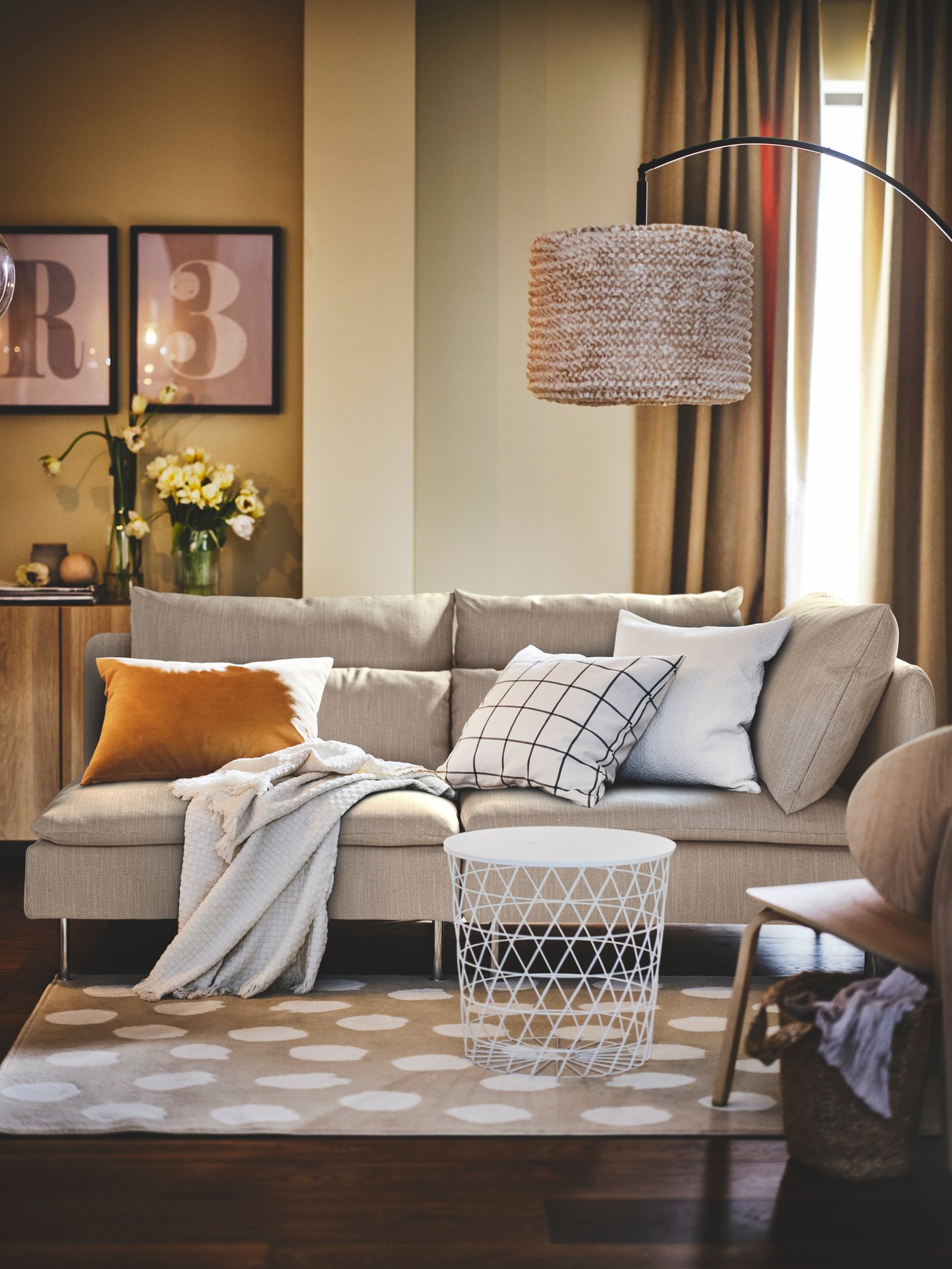 Es ist ein Wohnzimmer in warmen Farbtönen mit einem grauen SÖDERHAMN Sofa zu sehen.