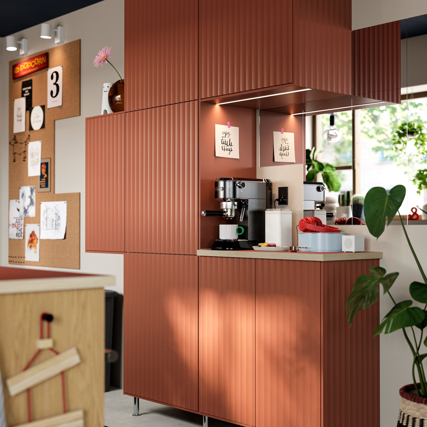 Une cuisine équipée de meubles SEKTION avec portes décoratives TERRSJÖ à motif ondulé rouge-brun, fixés au mur.