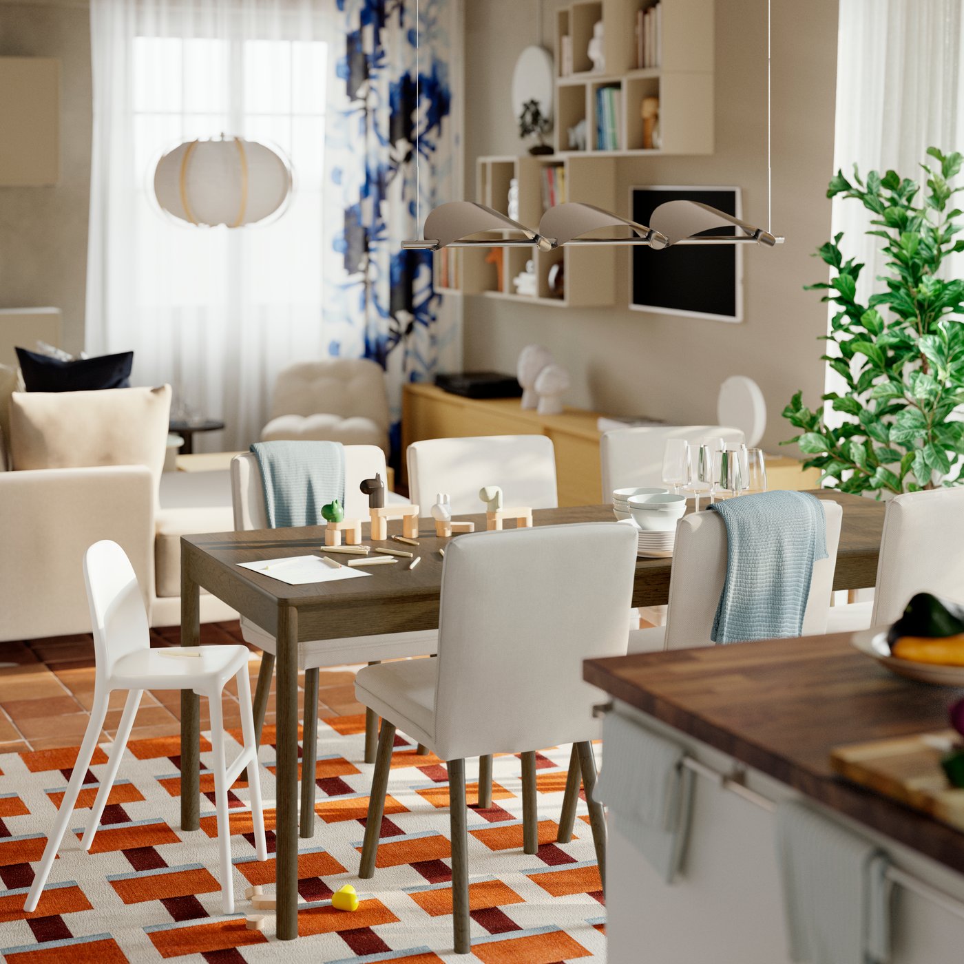 A TONSTAD extendable table with chairs is placed on a colourful rug in a dining room between a kitchen and living room.