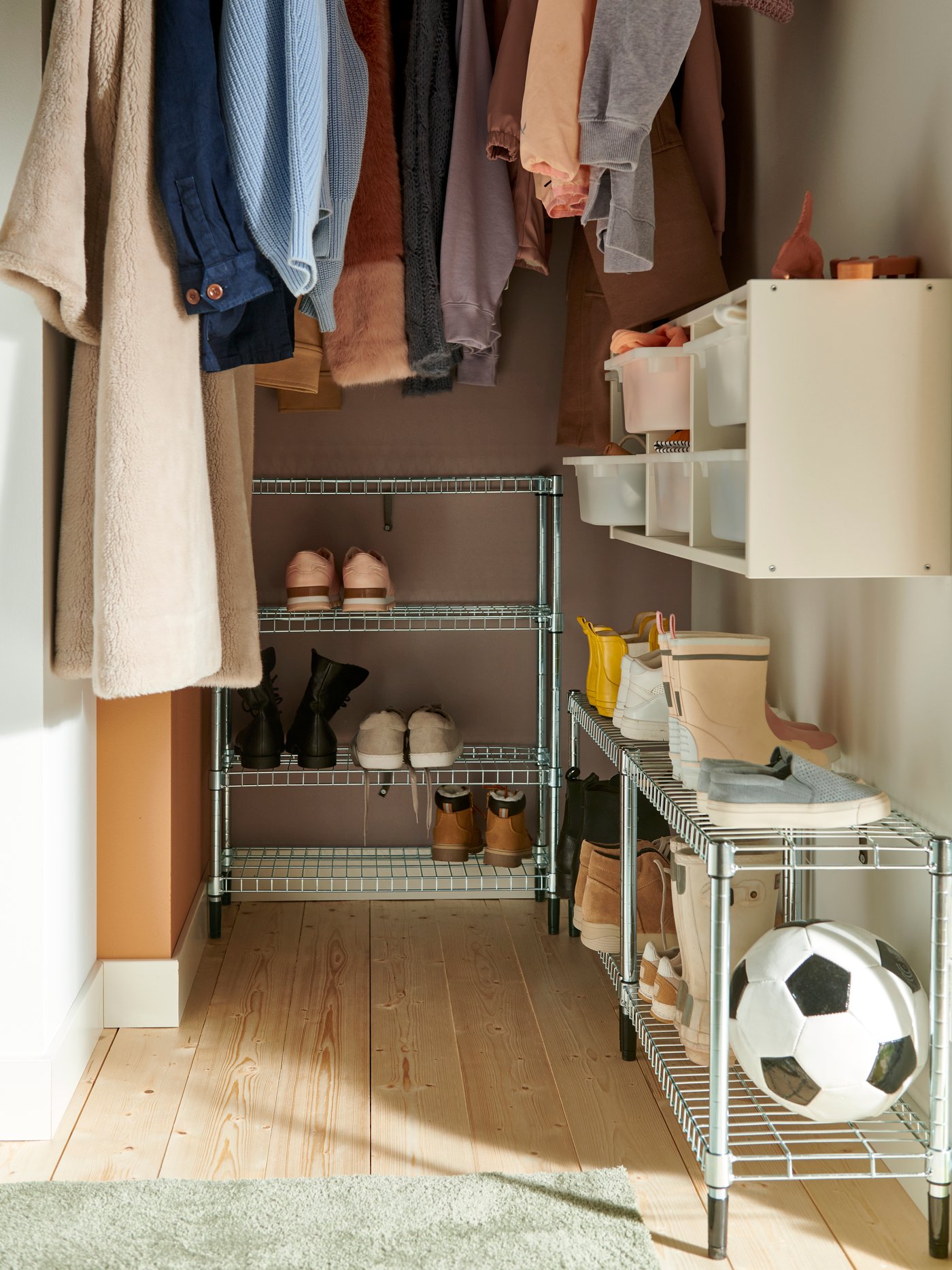 Several OMAR shelving units are filled with seasonal footwear in a nook in a hallway.