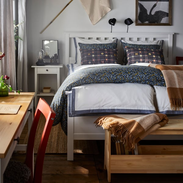 A bedroom with a HEMNES bed frame fitted with TÅTELSMYGARE bed linen and two pillows in KUSTGRAN pillowcases.