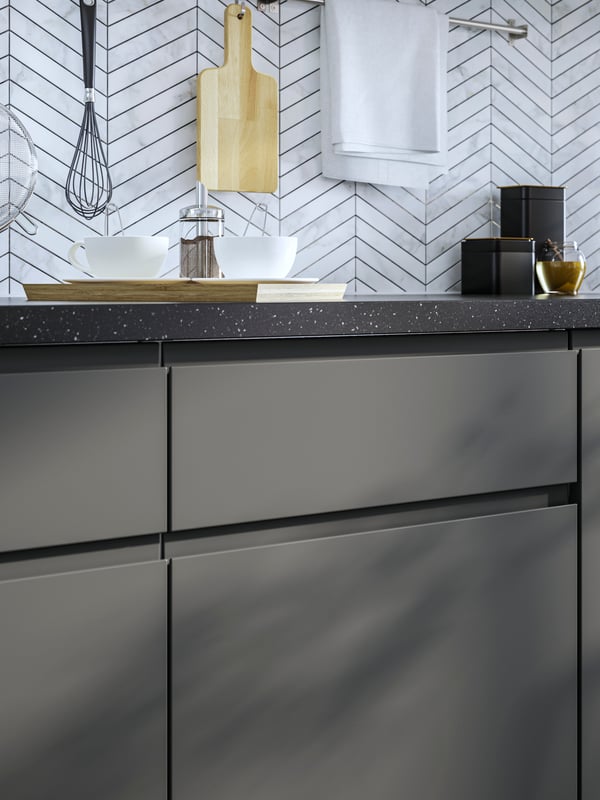 A dark grey VOXTORP drawer front