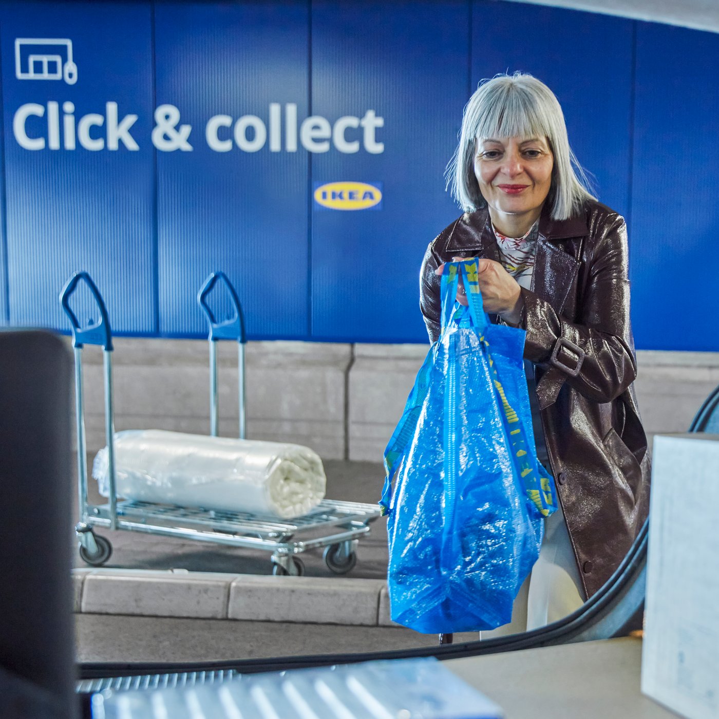 Woman is adding bag into a car