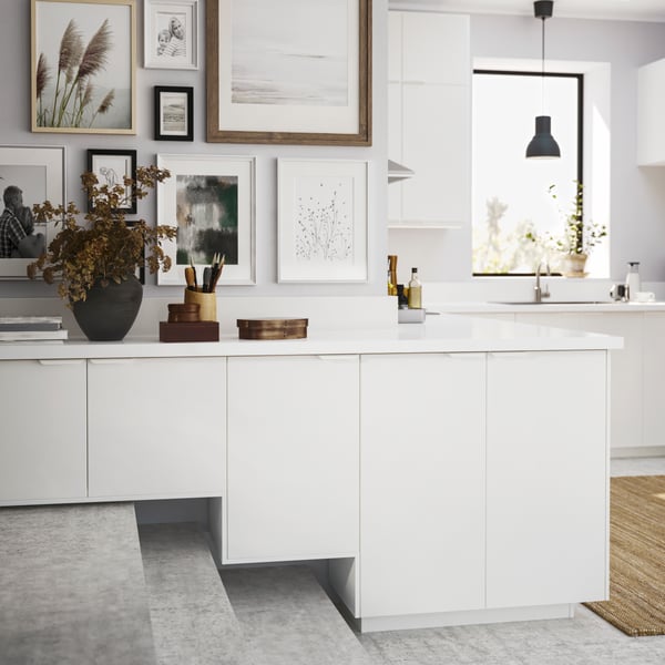 A combination of METOD cabinets and white VEDDINGE doors, its bottom edge following the profile of level-dividing steps.