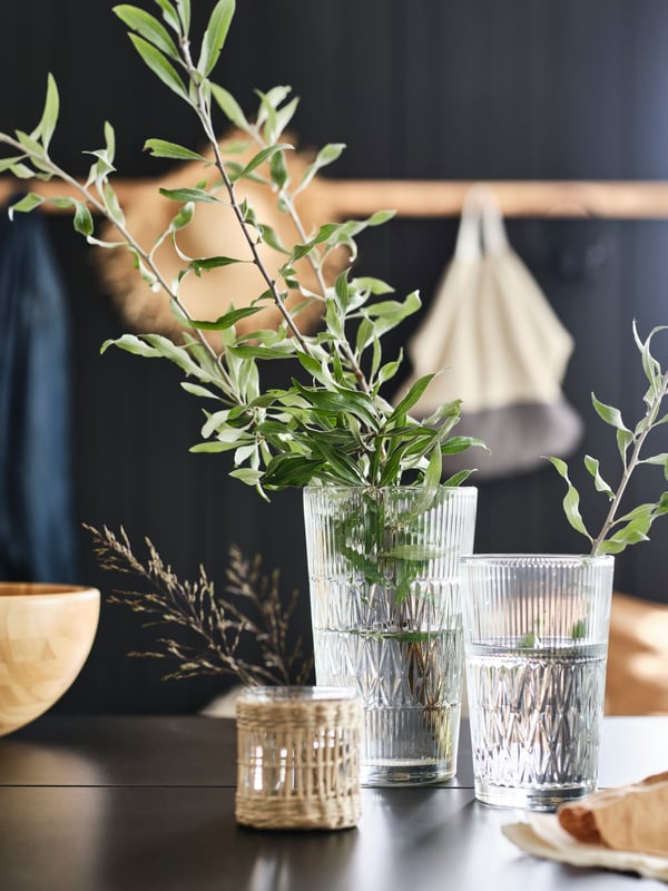 Two SMÄLLSPIREA vases in old-fashioned glass, matched with a small tealight holder in glass that has the same design.