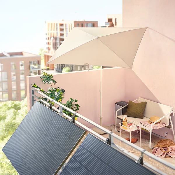 Deux panneaux solaires sont accrochés à l'extérieur d'un balcon.