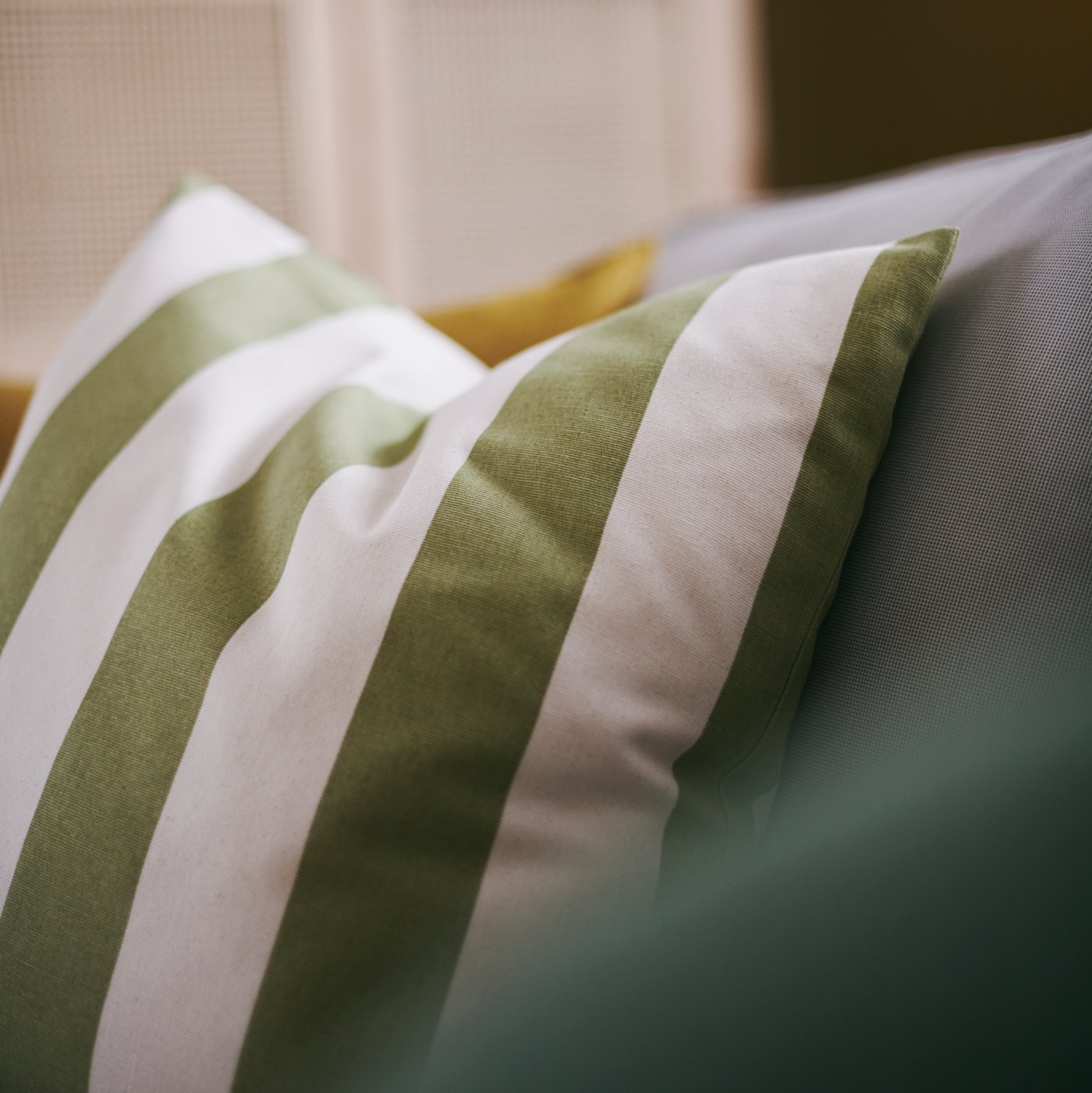 The HILDAMARIA cushion cover is made from 100% cotton and features stripes in green and a natural beige.