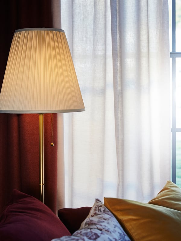 IKEA ÅRSTID brass/white floor lamp in the living room.