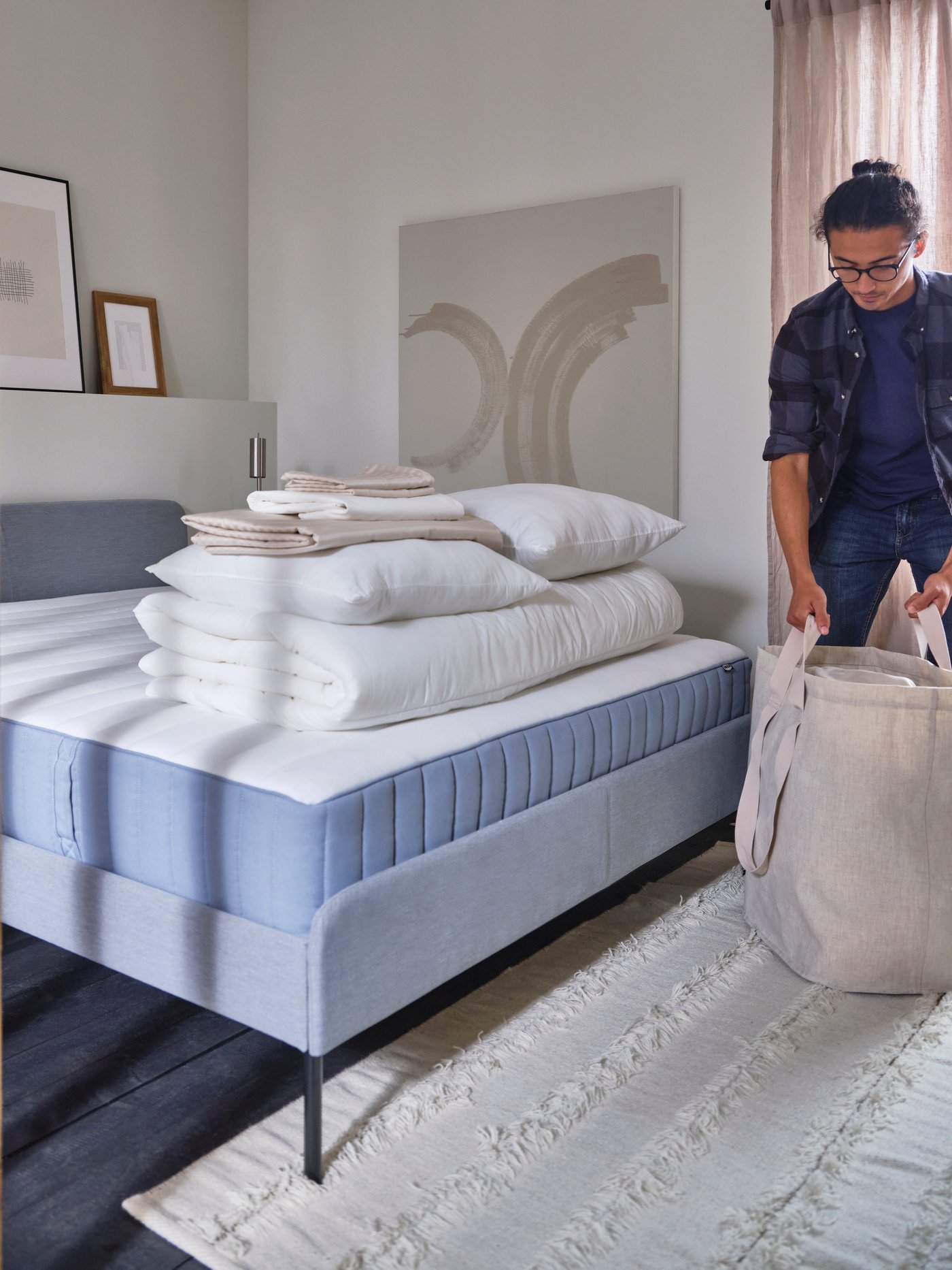 A bedroom with a white bed with white bed linen, blue walls and floors and French windows opening onto a balcony.