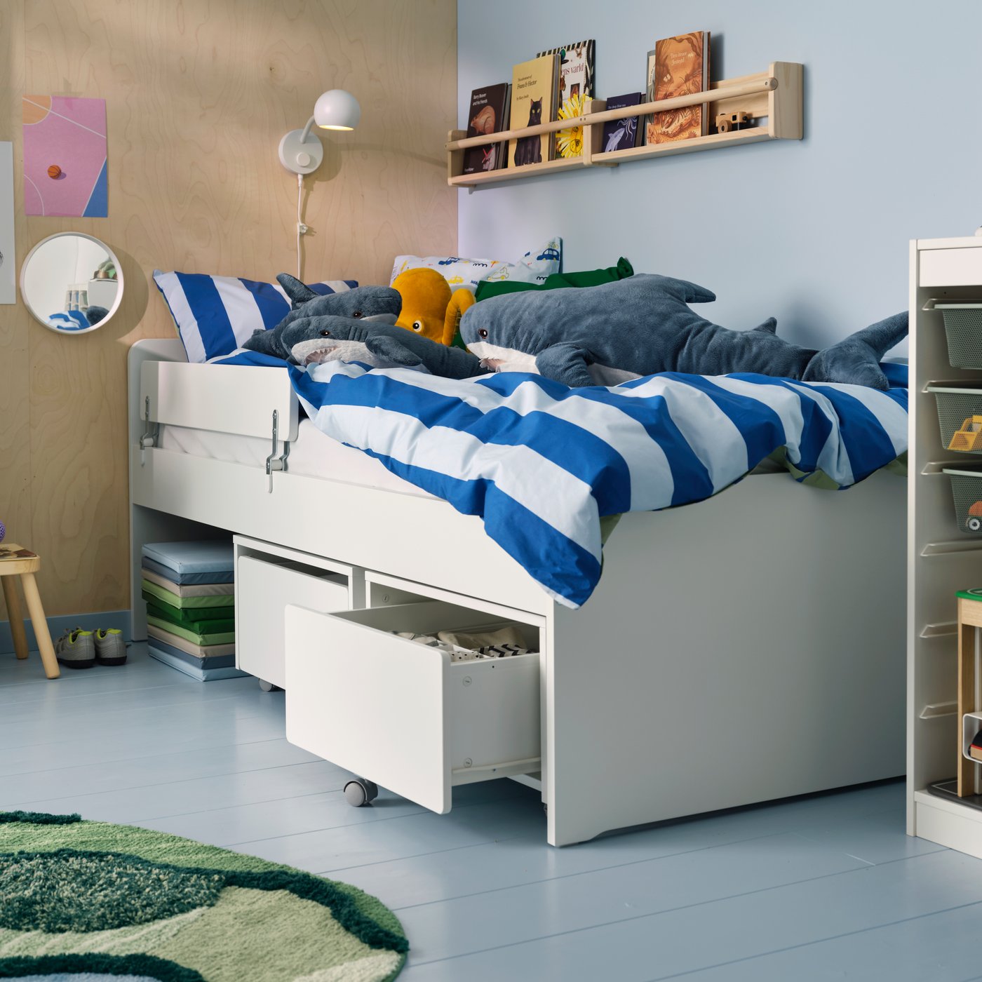 A white SLÄKT storage box with castors in the childrens room