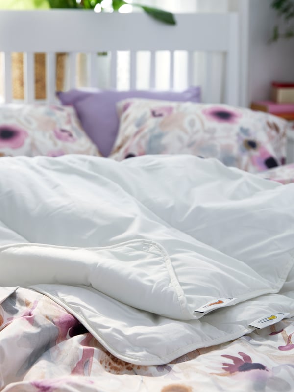 A STJÄRNBRÄCKA all seasons duvet lies on an IDANÄS bed with LÖNNHÖSTMAL bed linen and a pillow in a NATTSVÄRMARE pillowcase.