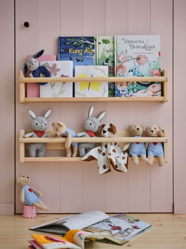 Two FLISAT wall storage on a wall above each other holding hard back books and soft toys including a FABLER BJÖRN soft toy.