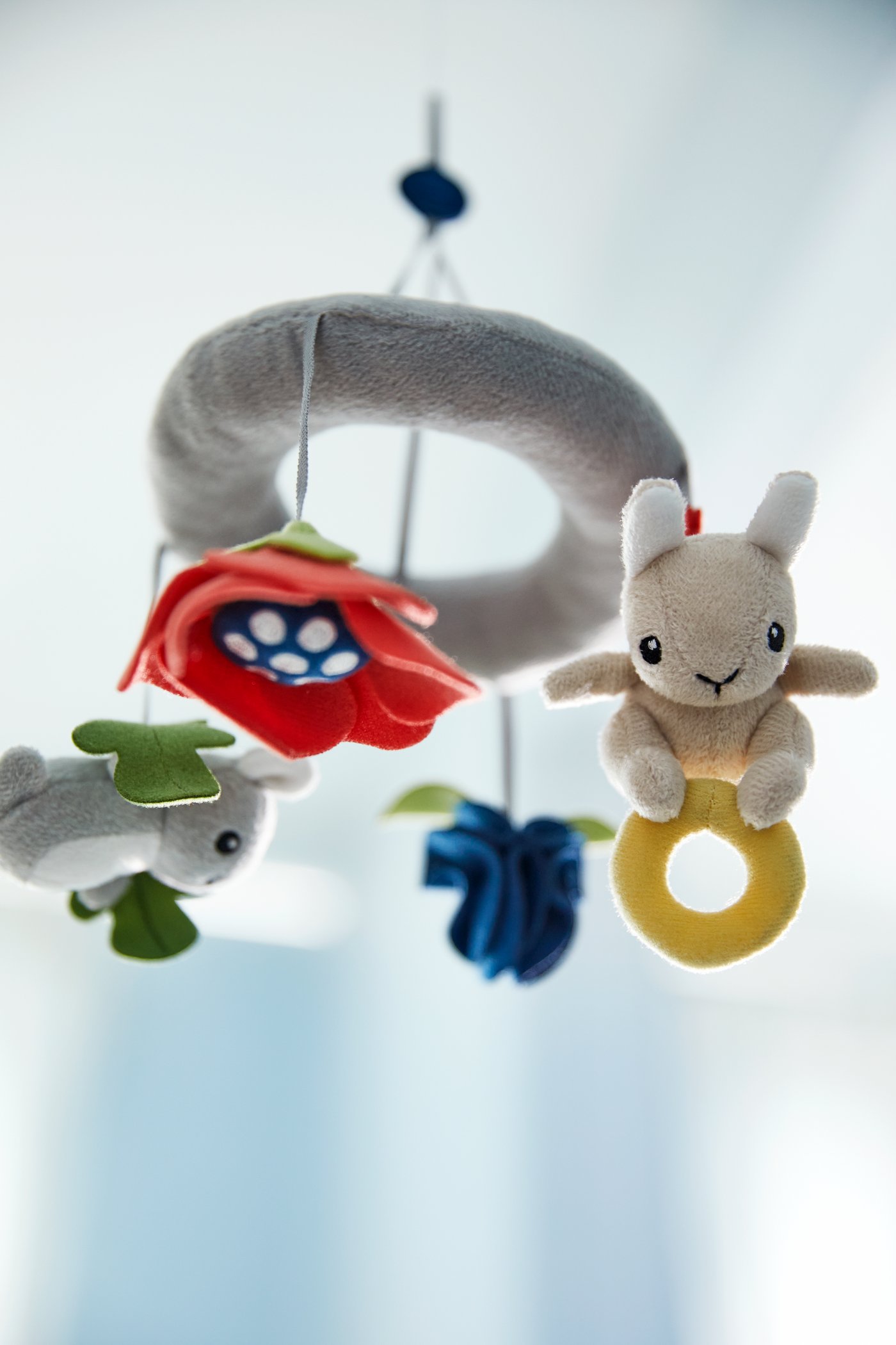 Plišana IKEA viseća vrteška za bebe GULLIGAST sa slatkim životinjama i raznobojnim cvećem.