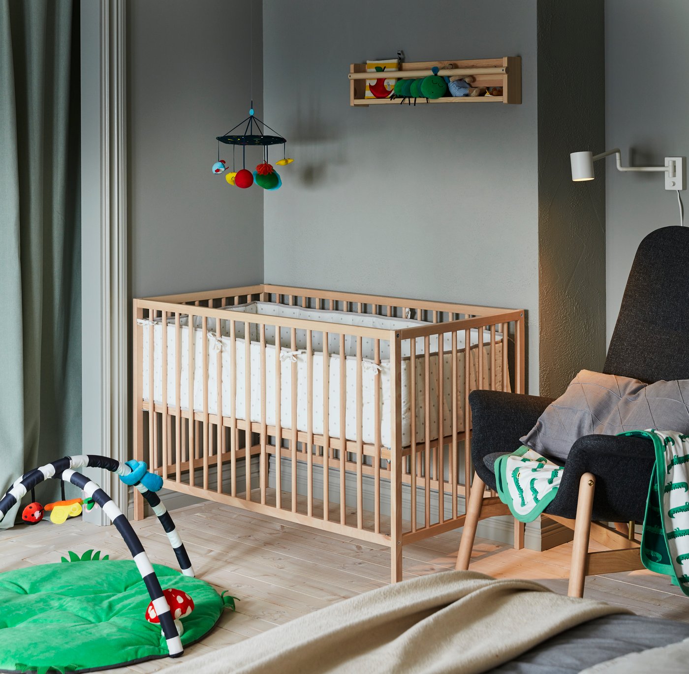 A crocodile/green RÖRANDE blanket in the childrens room