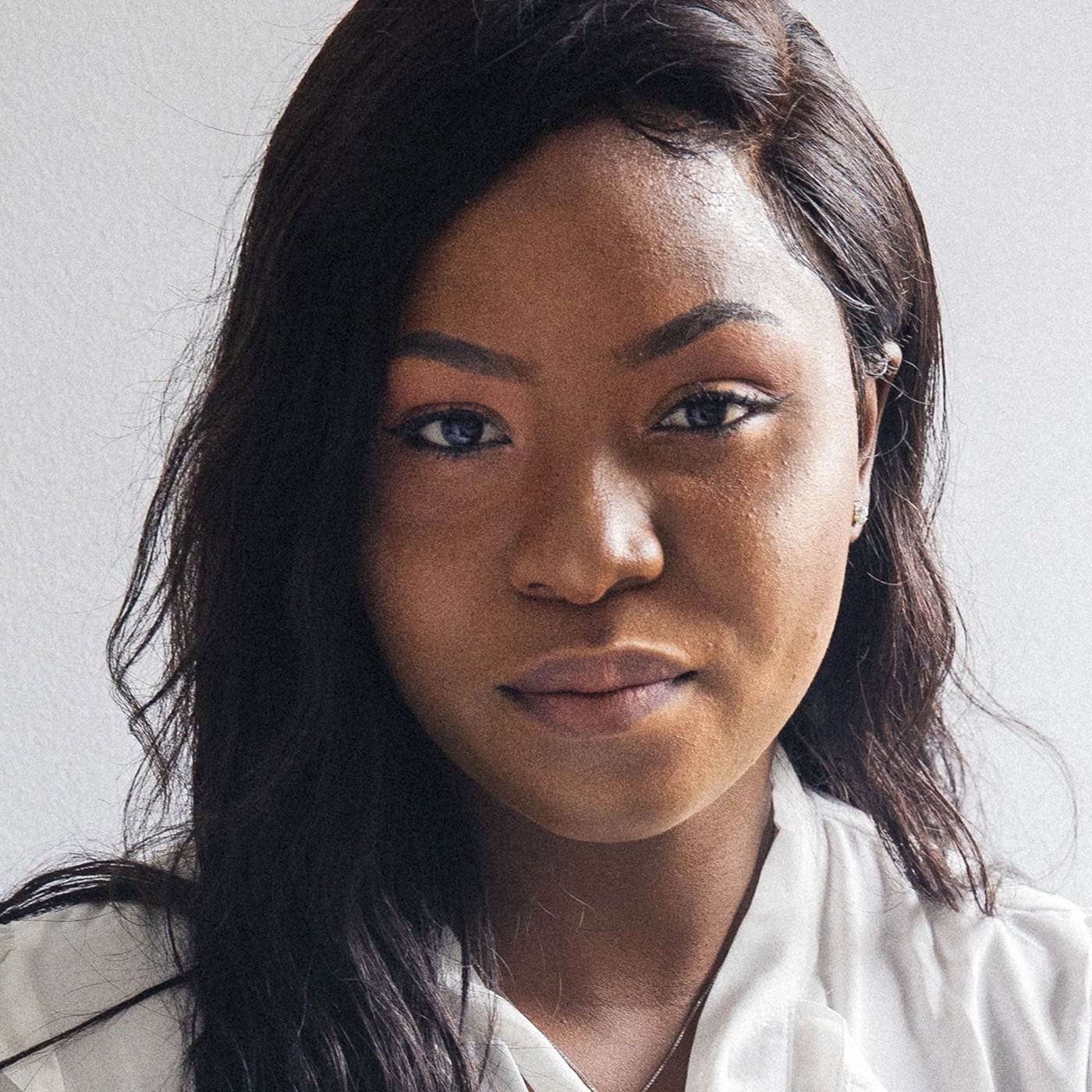 Portrait de Precious, réfugiée nigériane et collaboratrice IKEA Canada, portant un chemisier blanc.