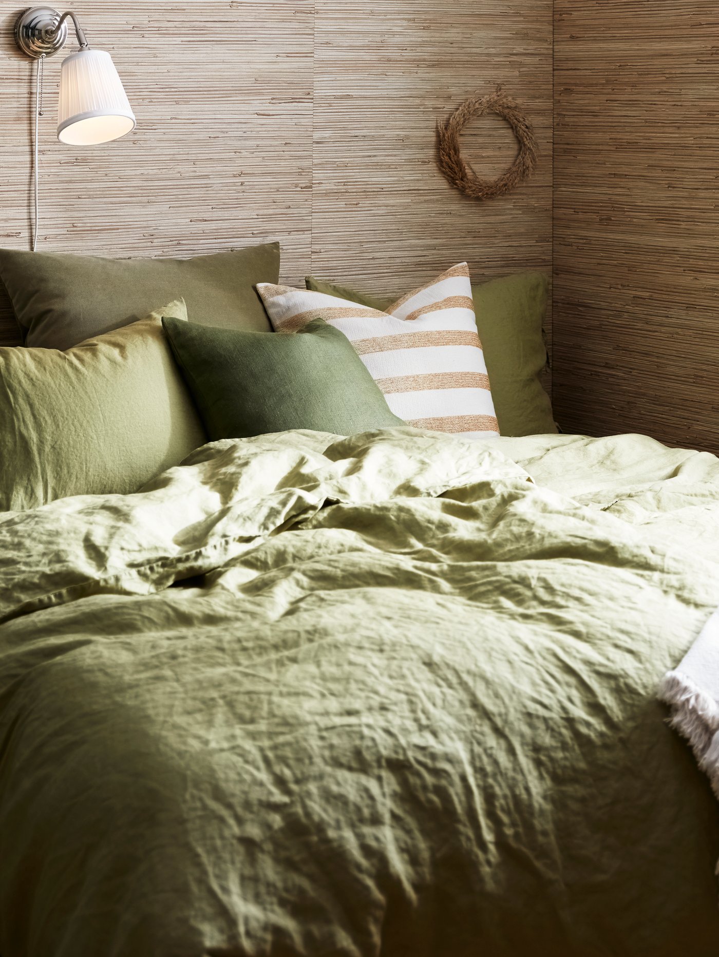 A natural golden-yellow/striped KNIPPARV cushion in the bedroom