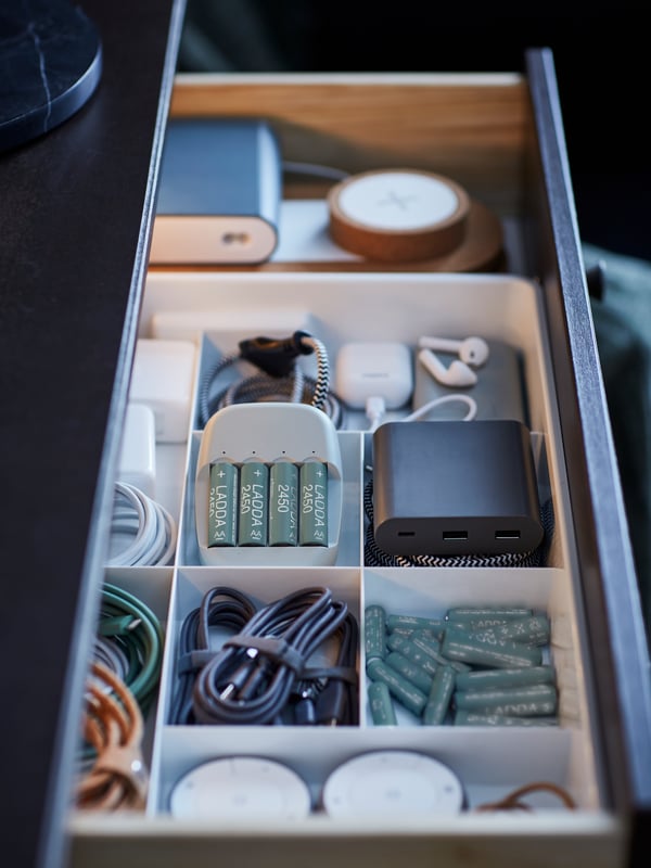 Offene Schublade mit Kabeln und Batterien