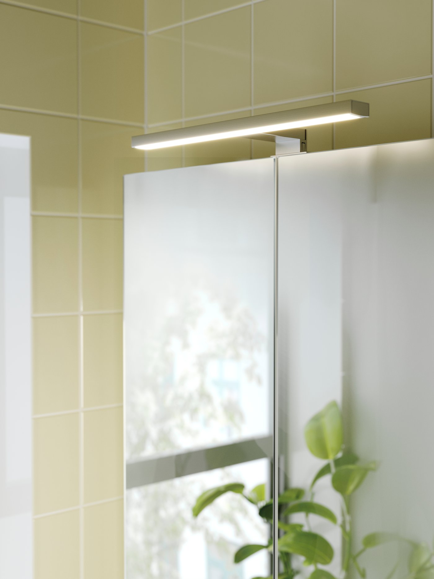 An aluminium-colour VÅTHULT LED cab/mirror light in the bathroom