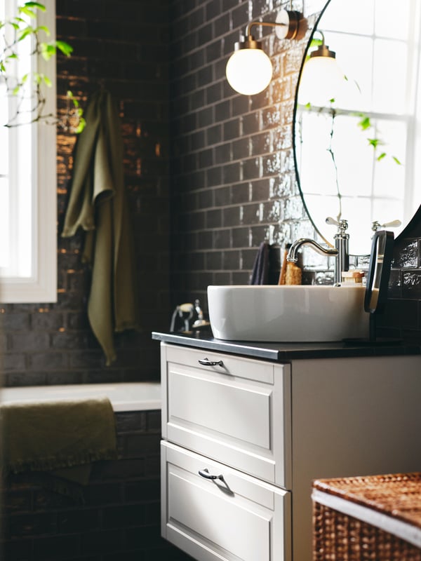 A light green VALLASÅN bath towel on a hook near a light grey GODMORGON wash-stand with 2 drawers below a LINDBYN mirror.