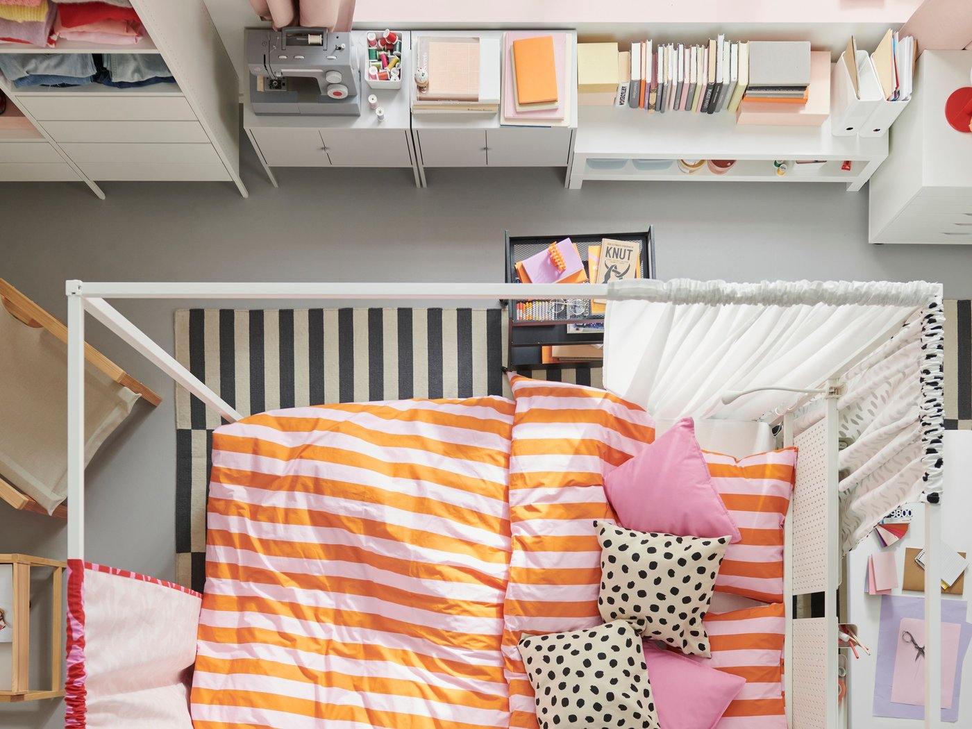 A bird’s eye view of a colourful bedroom. A white VITARNA four poster bed is in the centre, covered in SLÅNHÖSTMAL bed linen.
