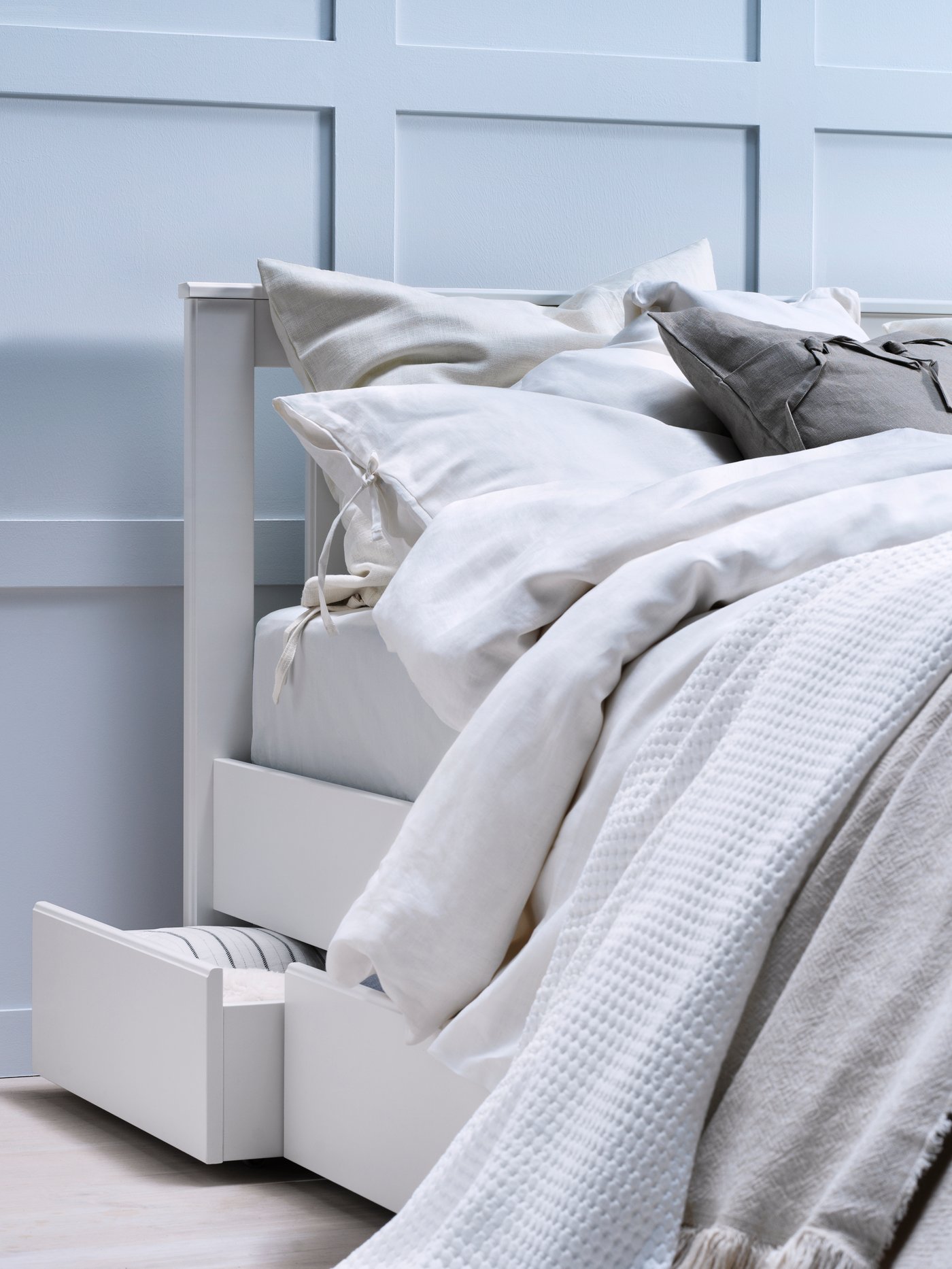 A grey AINA cushion cover in the bedroom