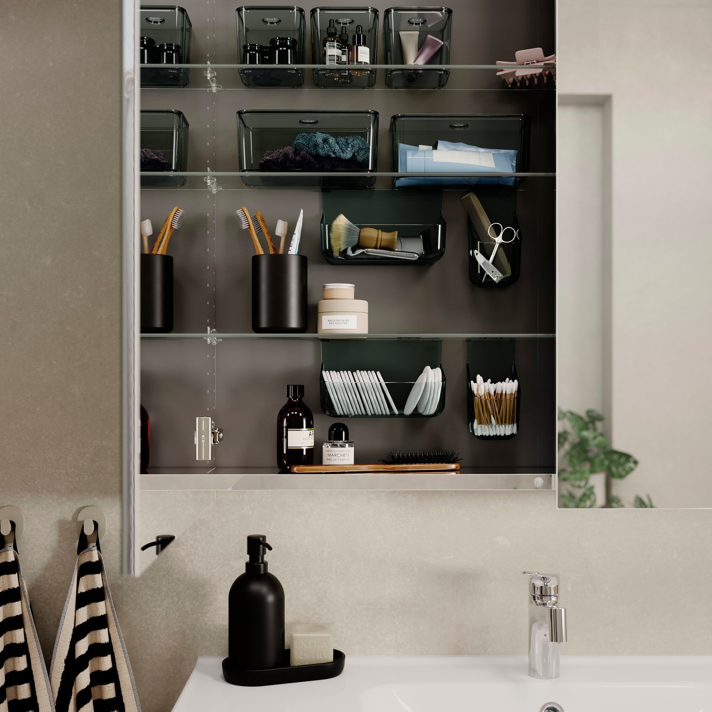 A bathroom with a high cabinet with open doors showcasing various VISSLAÅN inside organisers in transparent grey.