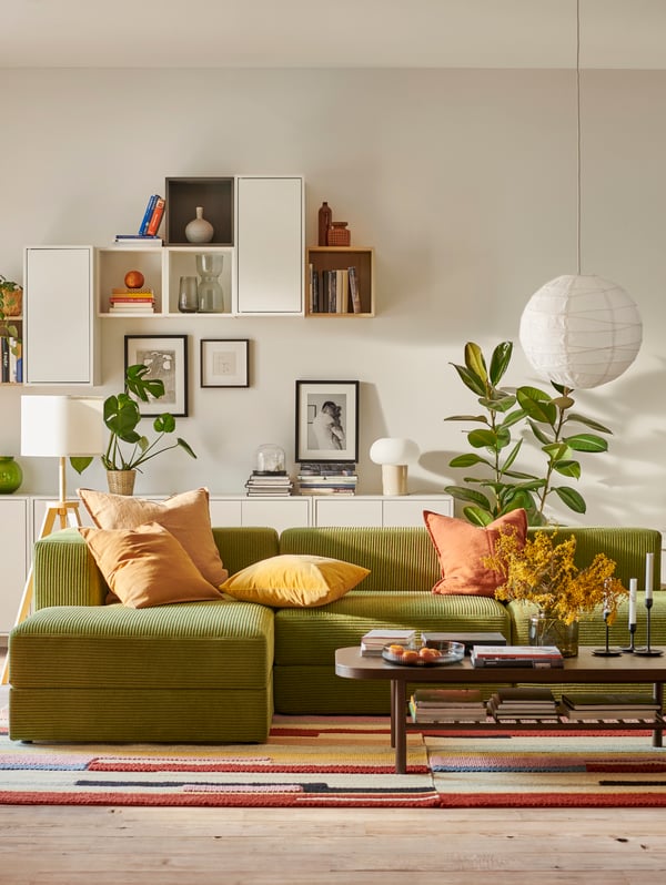 A JÄTTEBO 3.5-seat sofa with chaise longues and EKET wall-mounted cabinets are in a mid-century modern style living room.