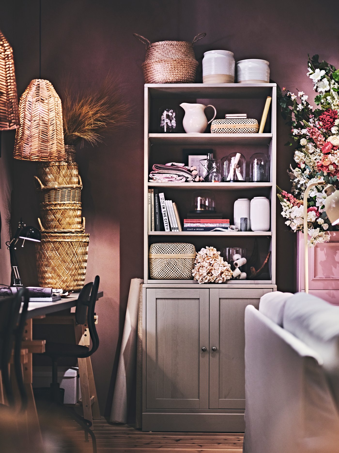 Combinaison de rangement HAVSTA grise pleine d’objets décoratifs, de livres, de paniers en rotin, de vases et de fleurs séchées.
