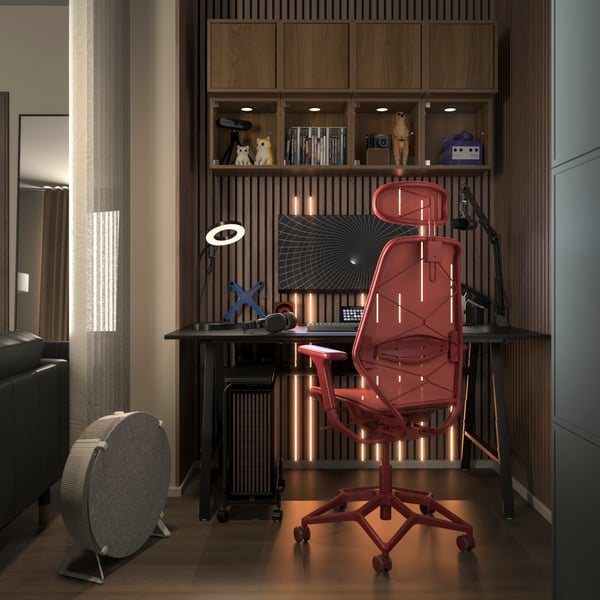 Un escritorio gamer UTESPELARE negro y una silla gamer STYRSPEL roja en un elegante rincón de una sala de estar moderna.