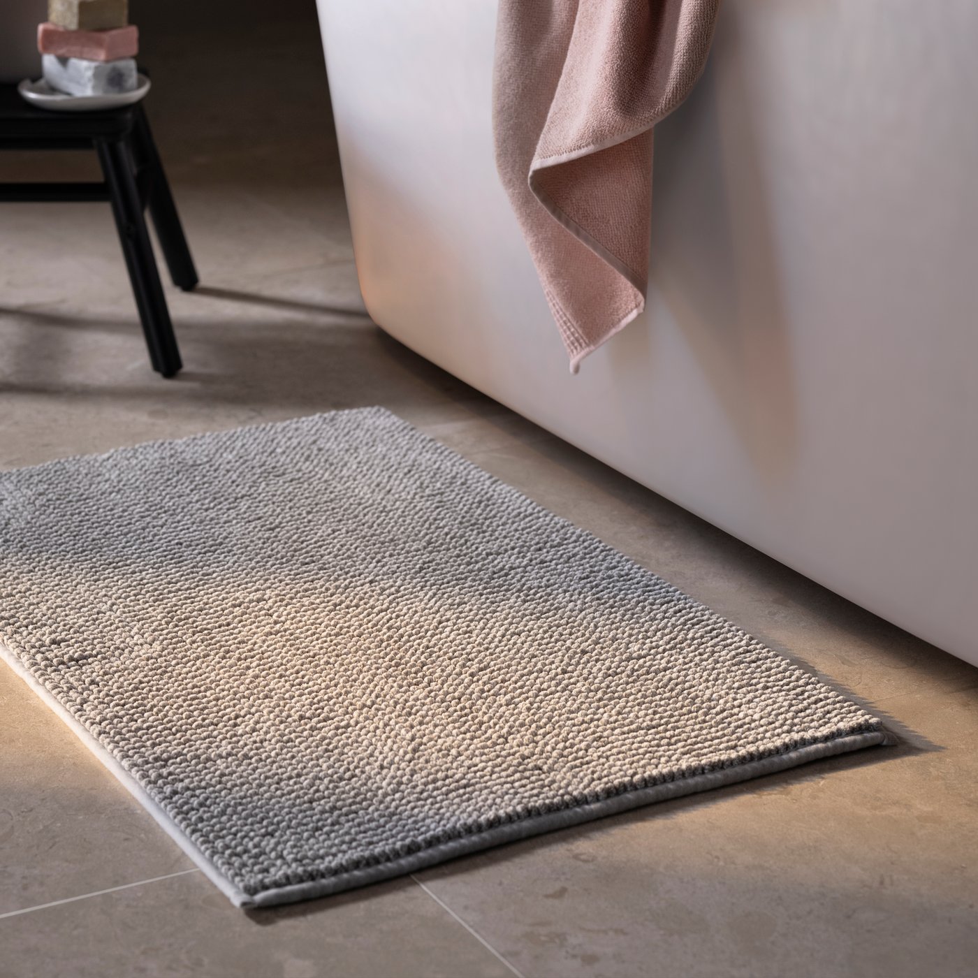 A grey-white mélange TOFTBO bath mat in the bathroom