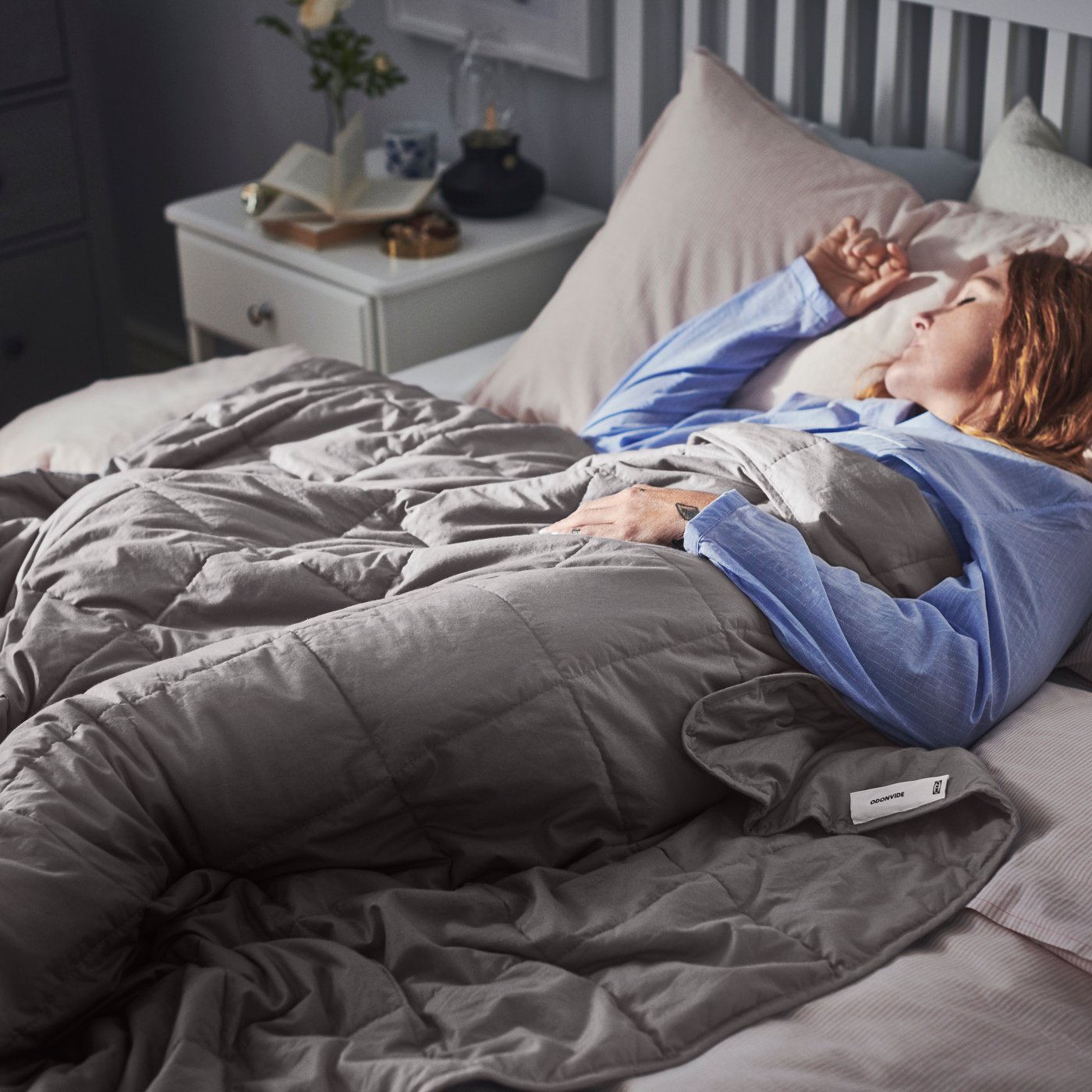 Una mujer recostada sobre una cama durmiendo.