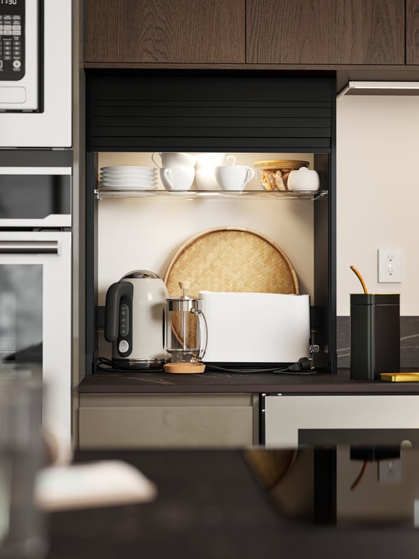 Une cuisine linéaire est équipée d’un rangement à rideau TITTEBO noir pour les petits électroménagers sur le comptoir et d’un refroidisseur à vin NUMRERAD.