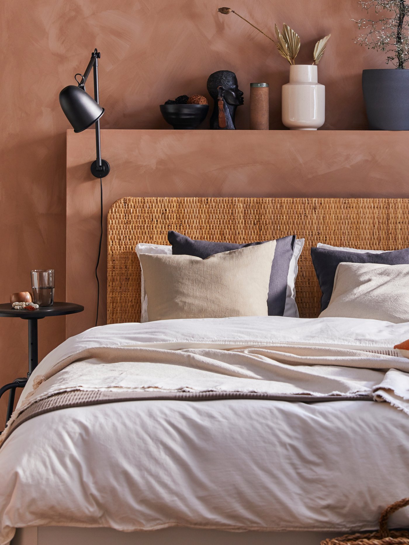 A bed with ÄNGSLILJA bedding, JOFRID throw and DVALA pillowcases.