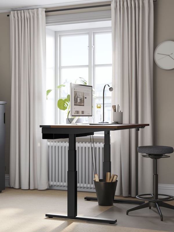An electric walnut veneer/black MITTZON desk sit/stand in the home office