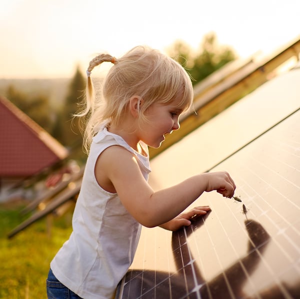 young child drawing on solar panel