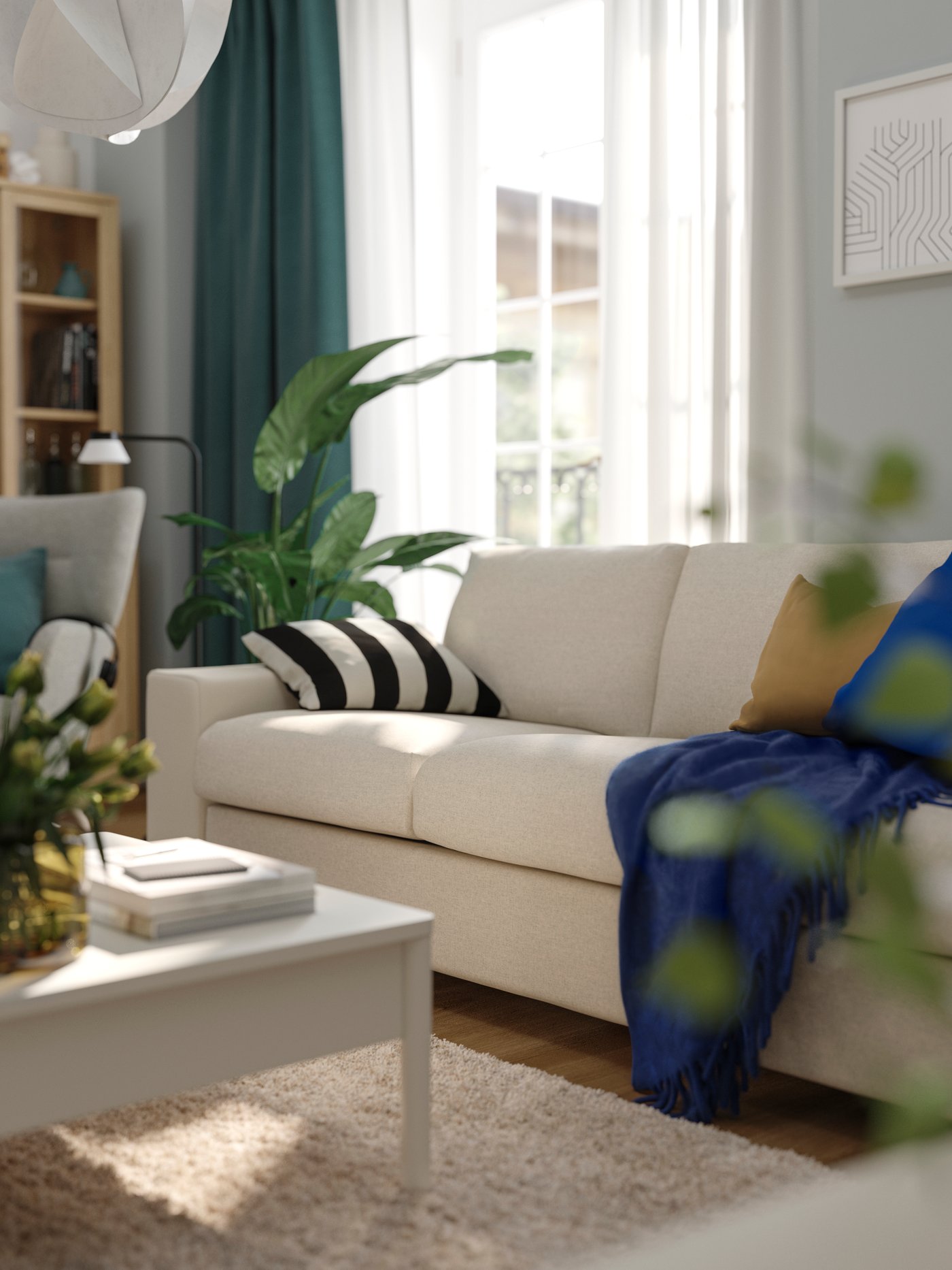 A beige VIMLE sofa in a light-filled living room with colourful cushions, TONSTAD coffe table and KLIPPOXEL blue throw.