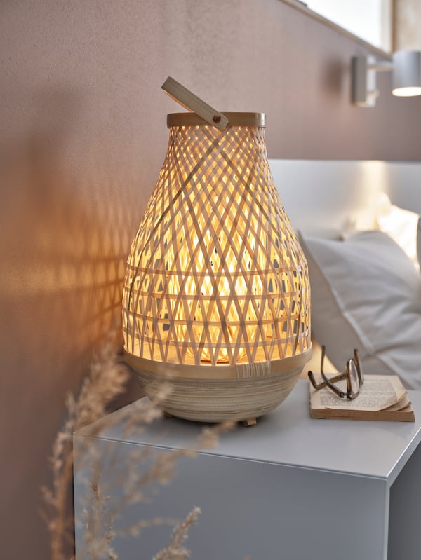 MISTERHULT bamboo table lamp sitting on a nightstand with a book and glasses.