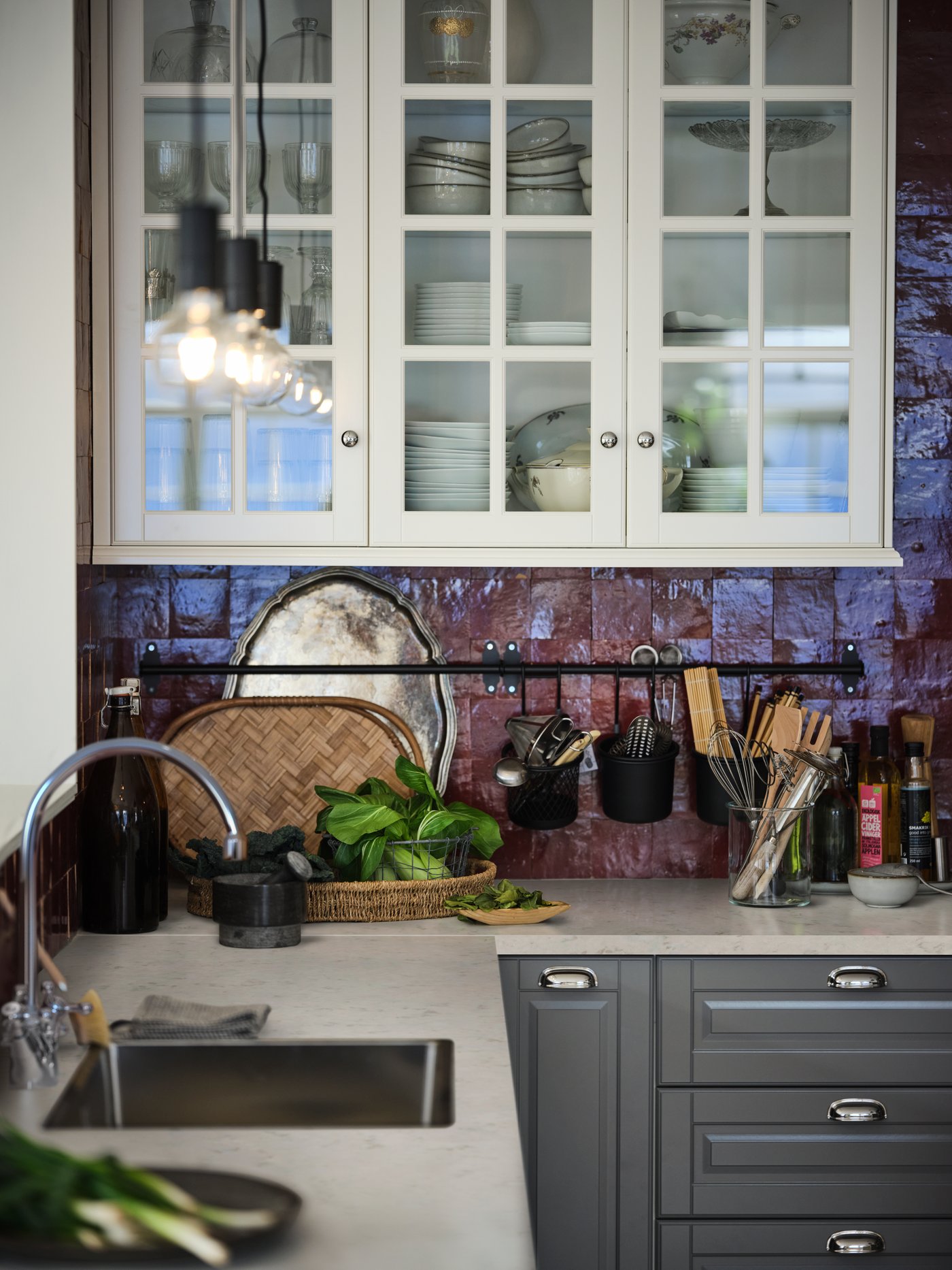 An EKBACKEN white-marble-effect worktop with grey METOD cabinets with MAXIMERA interiors in a red-tiled kitchen.