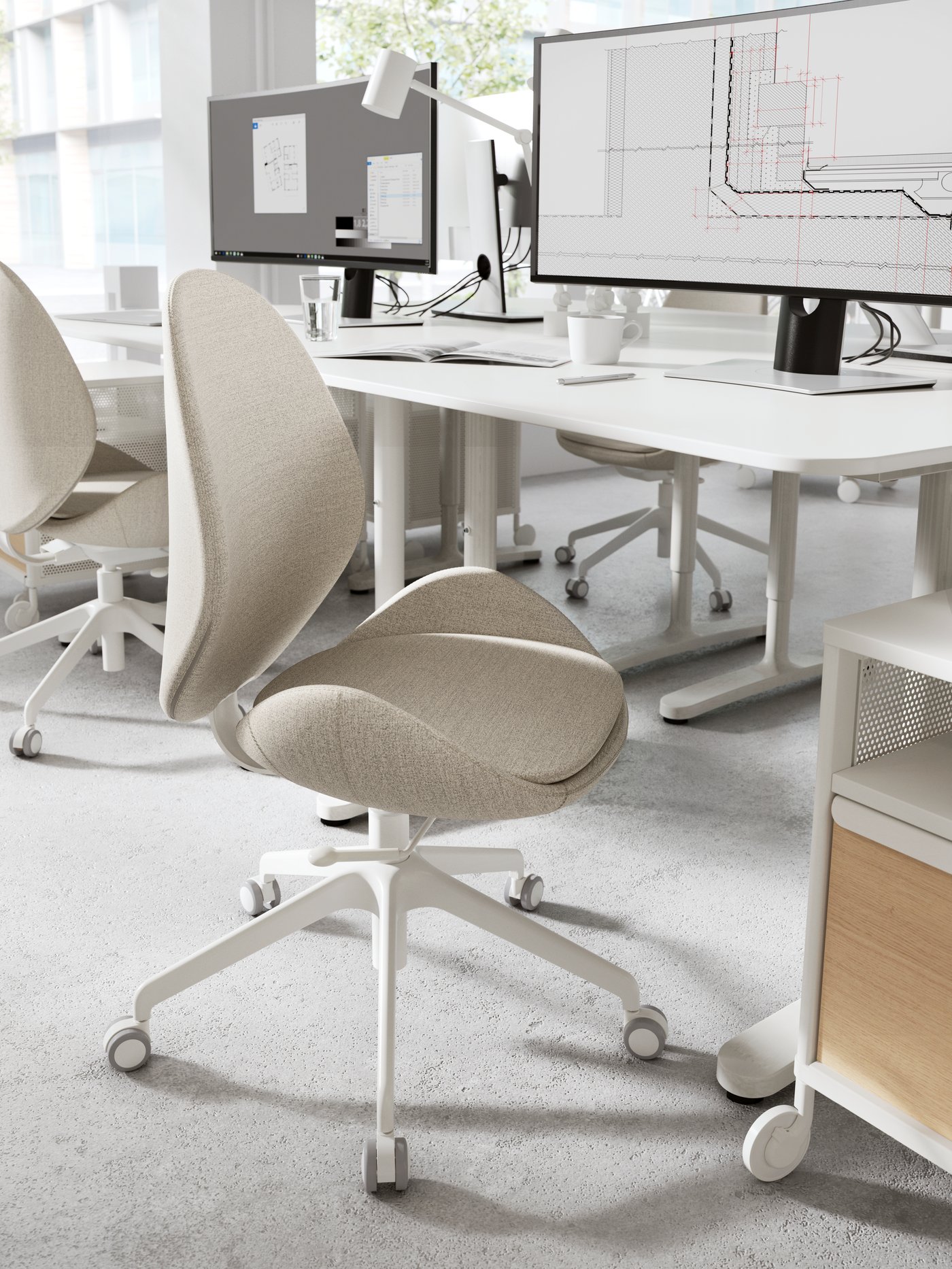 A HATTEFJÄLL office chair with beige fabric cover positioned in front of a white desk that has a computer on it.