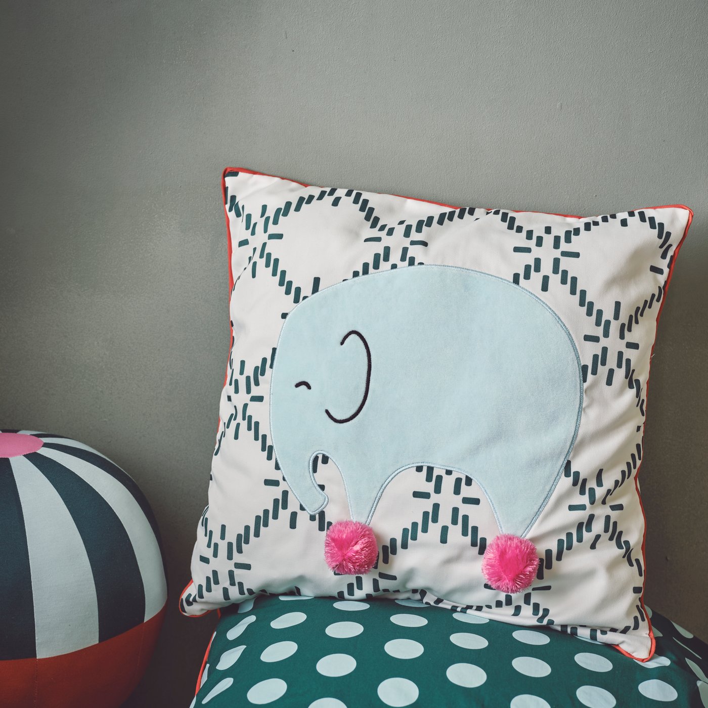 Ein grün-weisses gemustertes Kissen mit einem Elefanten darauf, setzt schöne Boho Akzente in jedem Kinderzimmer.