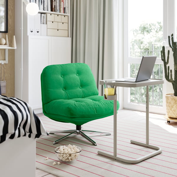 Una silla acolchada BJÖRKÅSEN c+omoda para trabajar frente a mesa para laptop.
