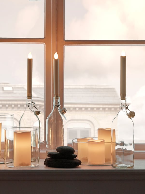 Several STORSINT wine glasses stending on the edge of a table top. 