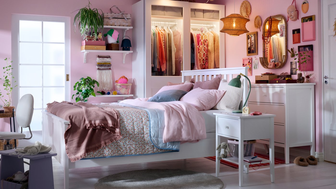 Bedroom in mainly light pink and white colours with HEMNES bed in the middle and PAX/GRIMO wardrobe in the back.