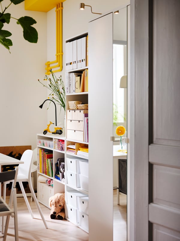 A VIHALS shelving combination with shelves holding storage boxes, file holders, baskets and children's toys.
