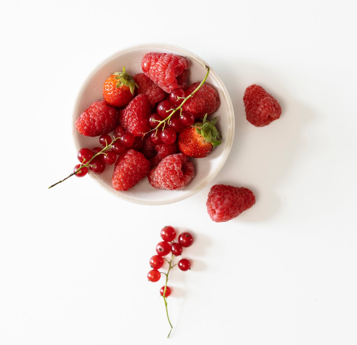 A Red berries light pink LOTSFÅGEL scented candle in glass in the NA
