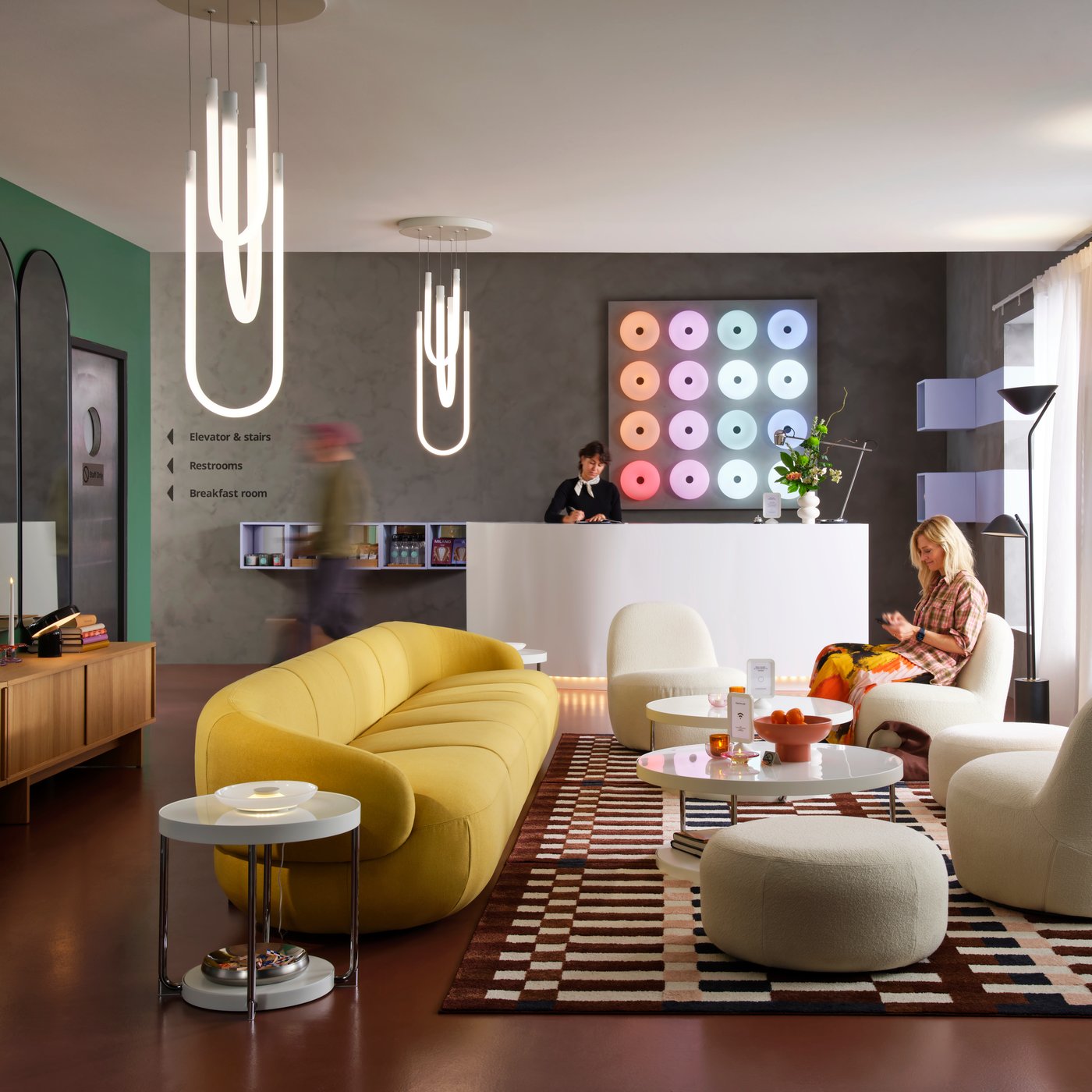 A LILLESÄTER 6-seat sofa in Gunnared bright green-yellow anchors a seating area in a modern hotel lounge with various people.
