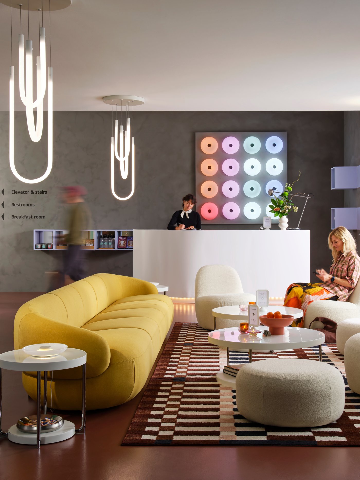A LILLESÄTER 6-seat sofa in Gunnared bright green-yellow anchors a seating area in a modern hotel lounge with various people.